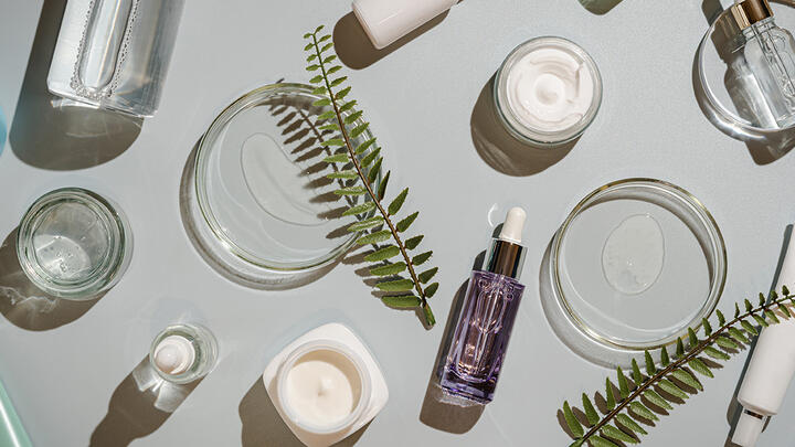 Various cosmetic bottles and Petri dishes on a bright surface